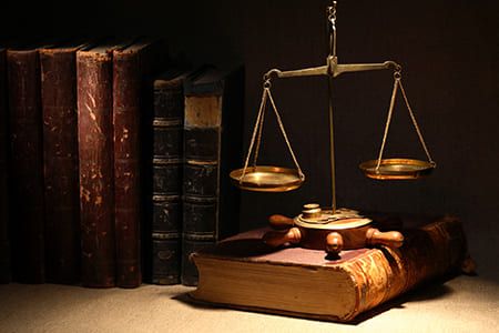 Iuris Sant Andreu balanza de la justicia y libros de leyes